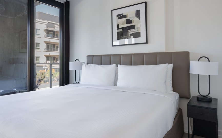 level hollywood spacious bedroom with premium linens and open air balcony